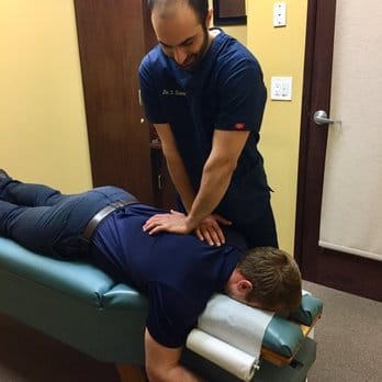 dr simian performing chiropractic adjustment for Burbank patient