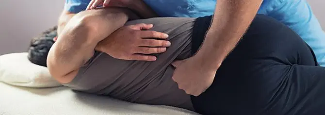 chiropractor adjusting patients back