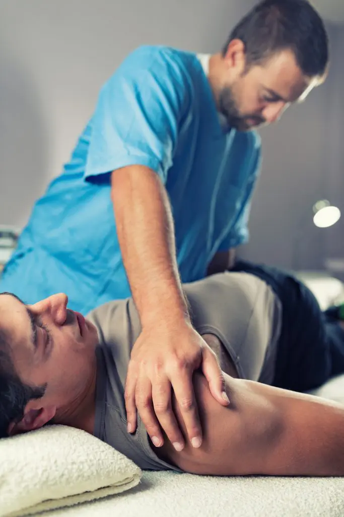 chiropractor adjusting male patients back 