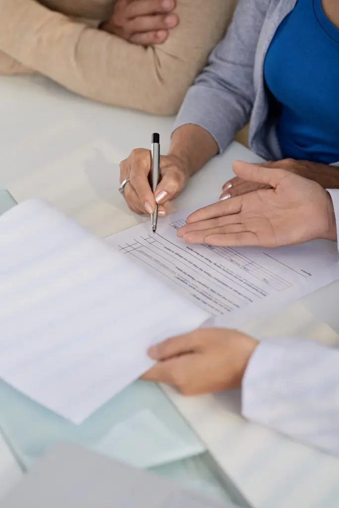 doctor asking patients to sign paperwork 