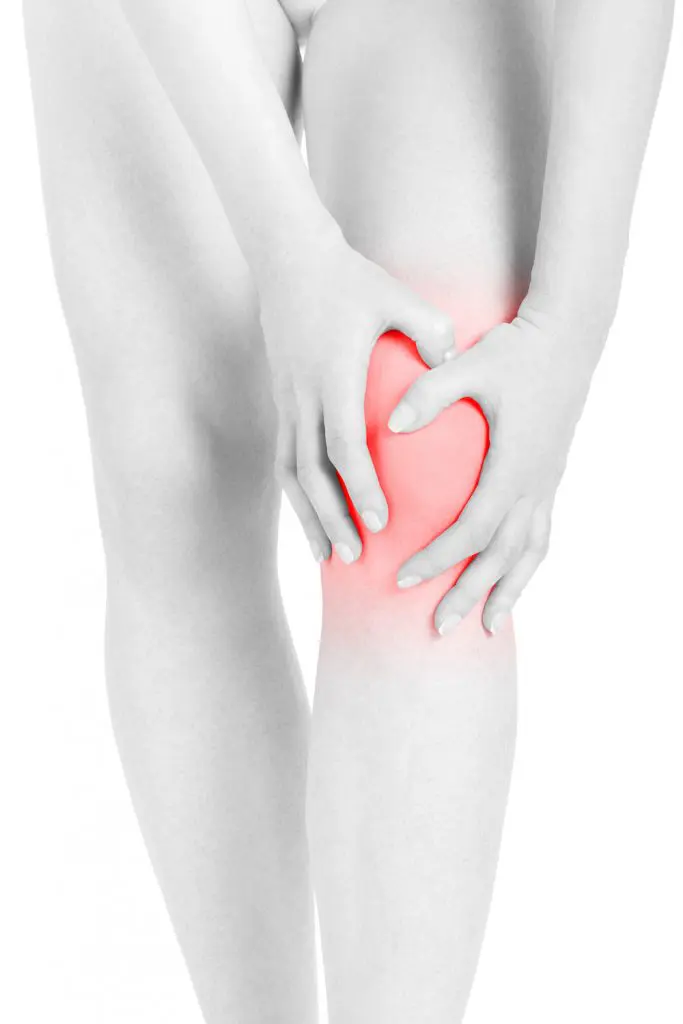 young female holding her knee due to inflammation 
