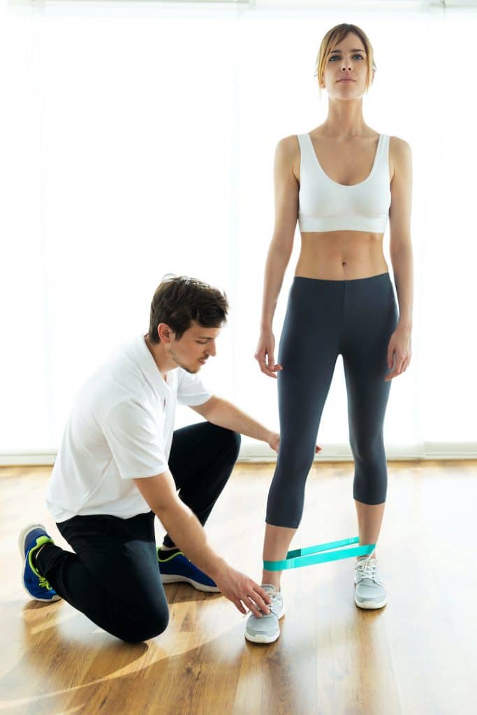 sports trainer showing his female client how to perform an exercise 