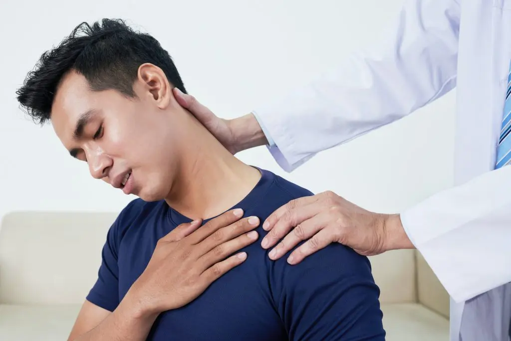 male patients neck being examined by a doctor
