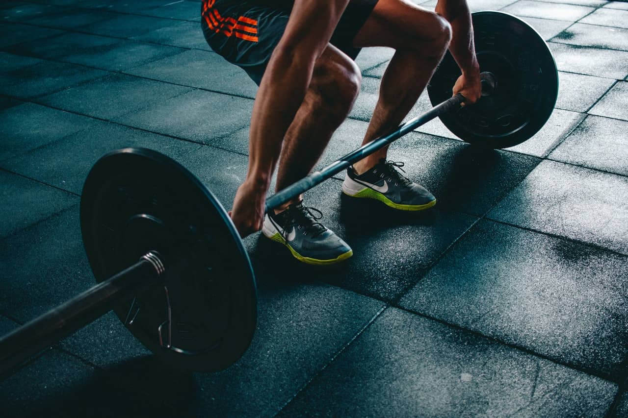 cropped image of an athlete about to lift a big dumbell