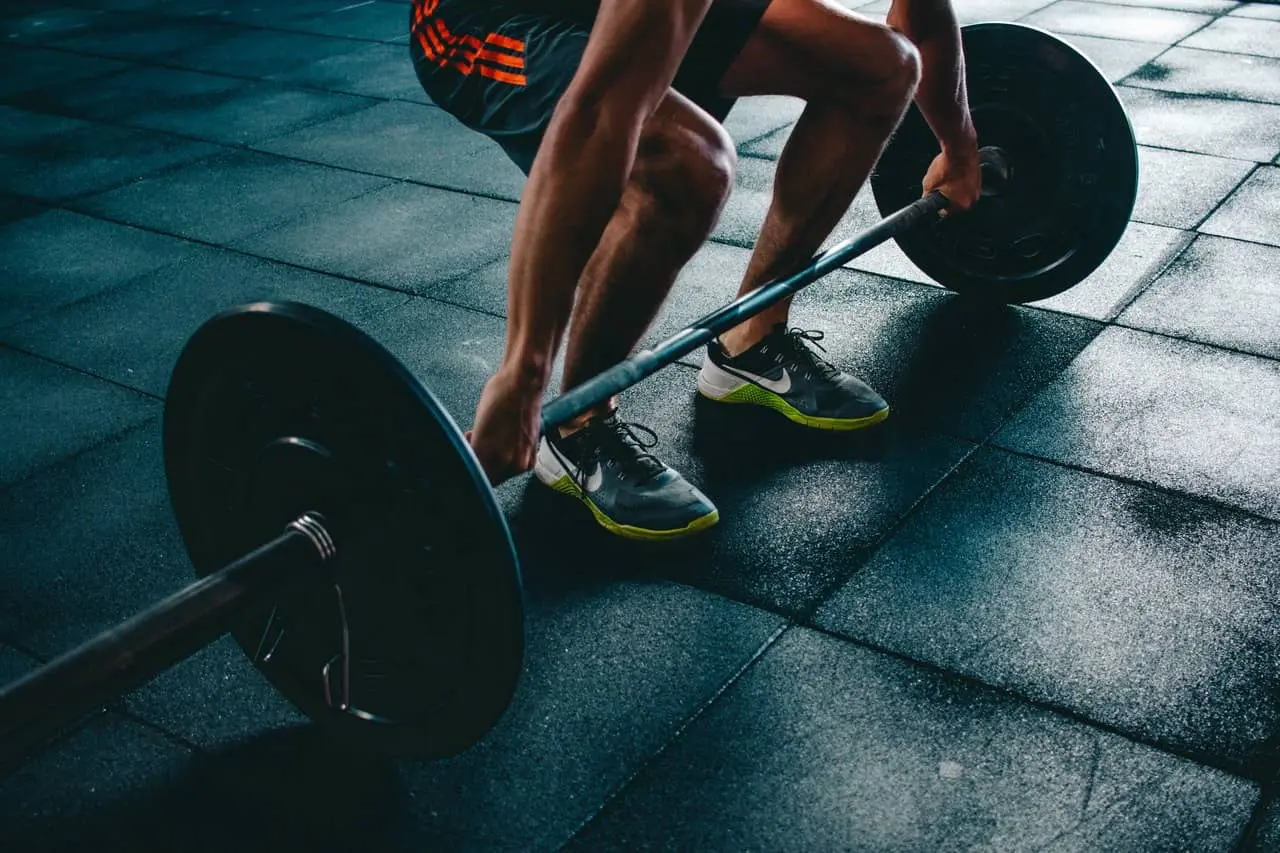 cropped image of an athlete about to lift a big dumbell