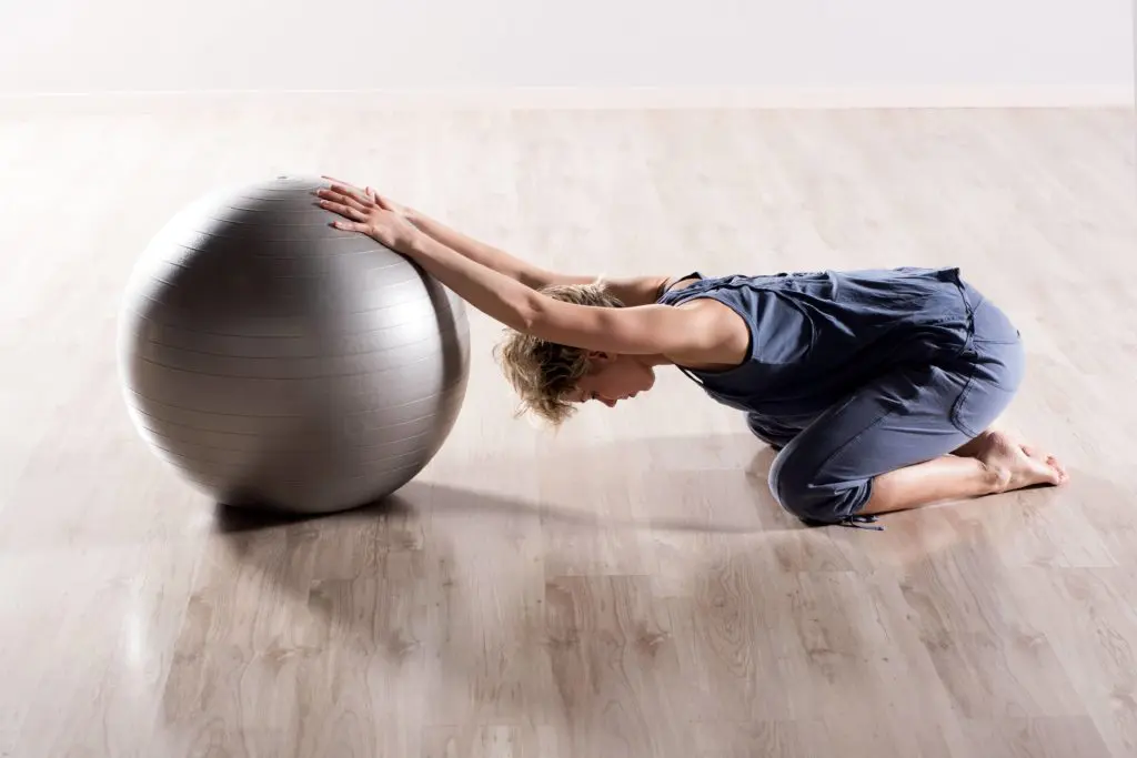 Woman doing stretching exercises with a balance ball.