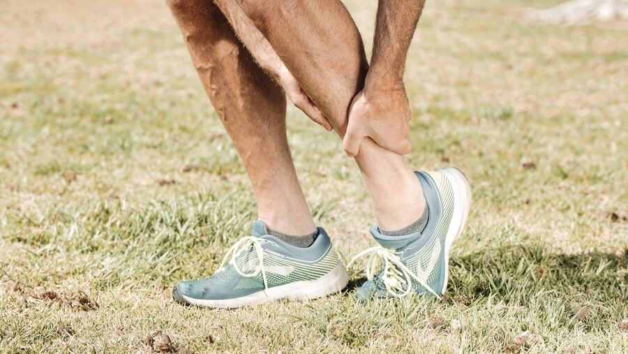 Runner holding his leg due to pain 