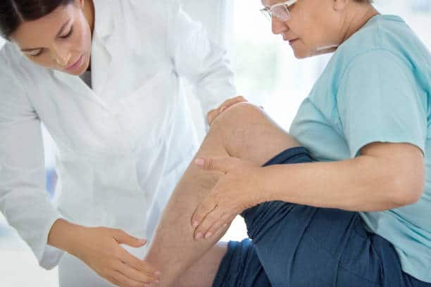 Chiropractor is treating the patients leg who suffers from severe leg pain