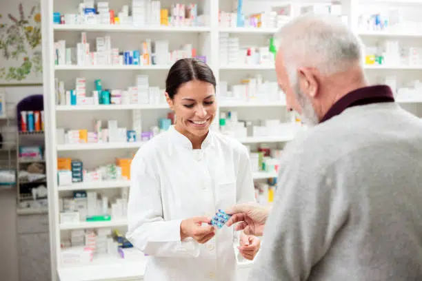 Female pharmacist giving the over the counter medicine to the patient for pain