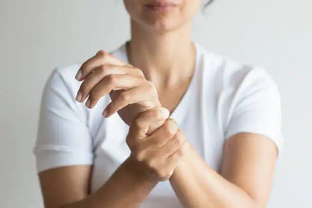 Woman holding her hand due to numbness and pain cause by Neuropathy