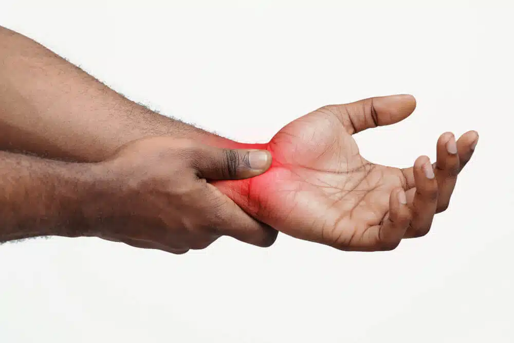 A man holding his hand and wrist due to intense pain