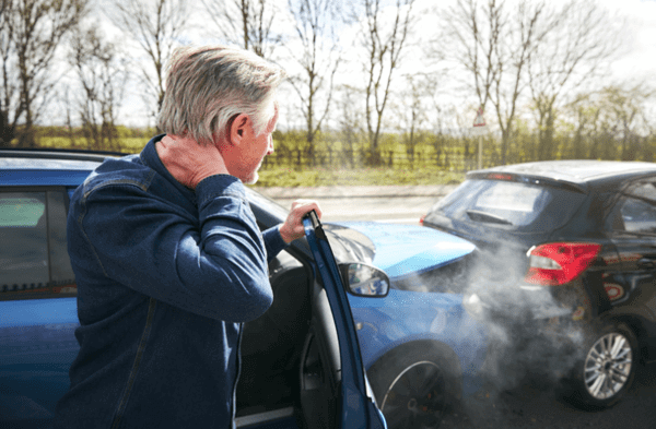 Man holding his neck feeling of intense pain after getting involved into an auto accident.