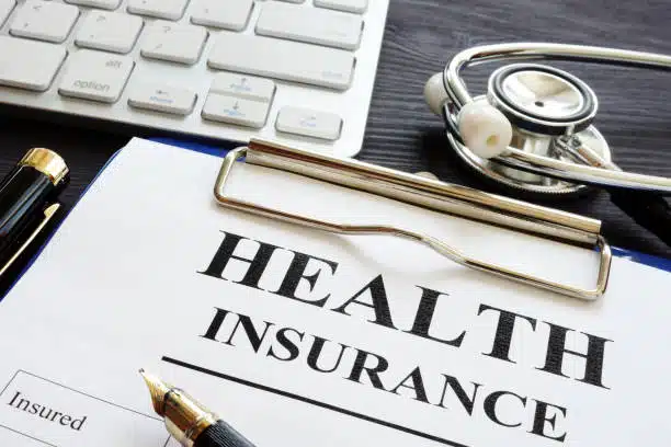 Health insurance document policy and stethoscope on the table. 