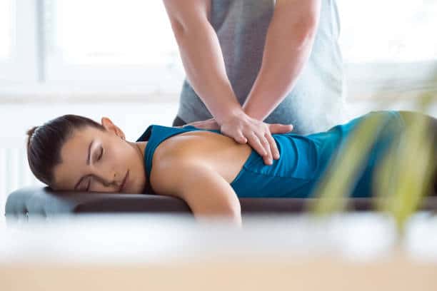 Chiropractor helping a patient while having a chiropractic adjustment.