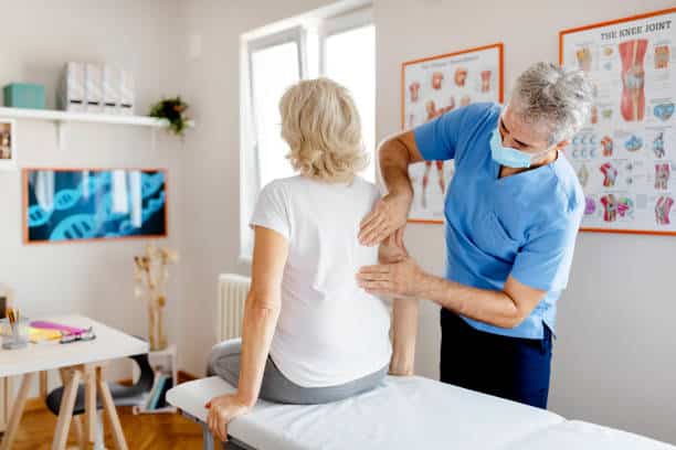 Senior Woman Having Chiropractic Back Adjustment.