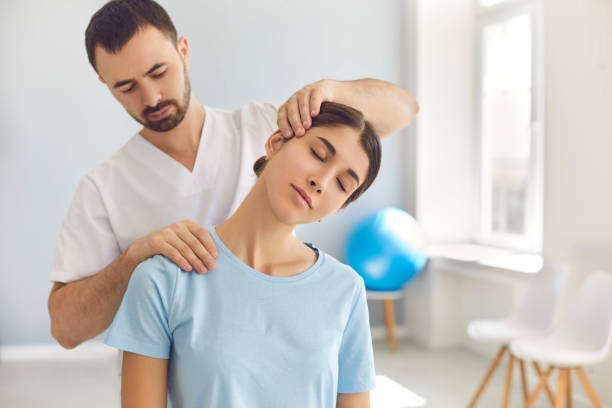 Chiropractor doing some neck stretches to the patient before doing some adjustments.