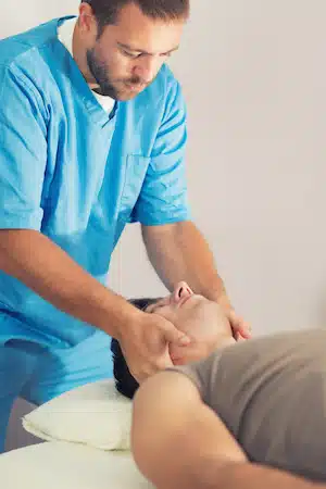 chiropractor giving head massages to patient experiencing vertigo