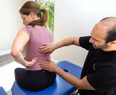 Dr. Simian examining patients back for personalized treatment of massage therapy in burbank