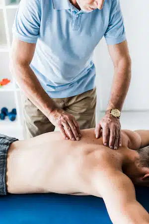 Chiropractor massaging the patient on the massage table