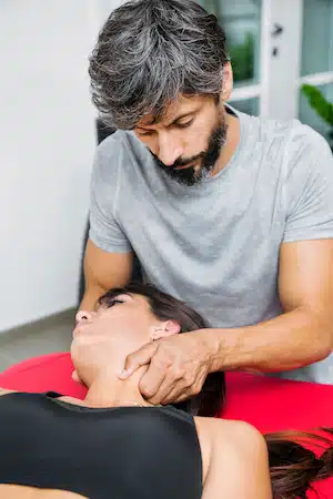 chiropractor doing jaw alignment for patient with tmj