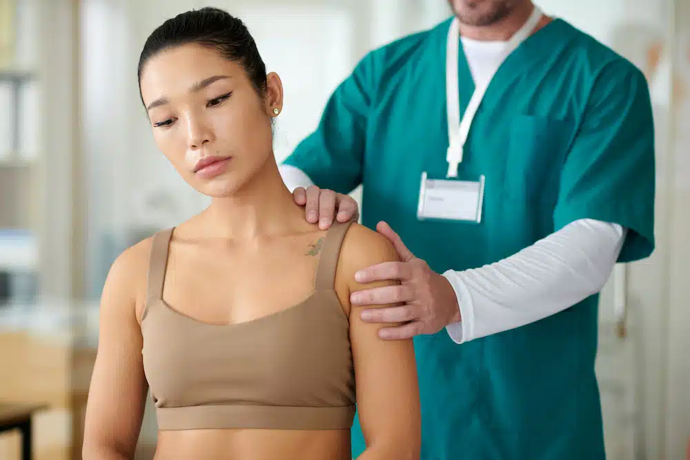 woman receiving chiropractic adjustment for strained muscle