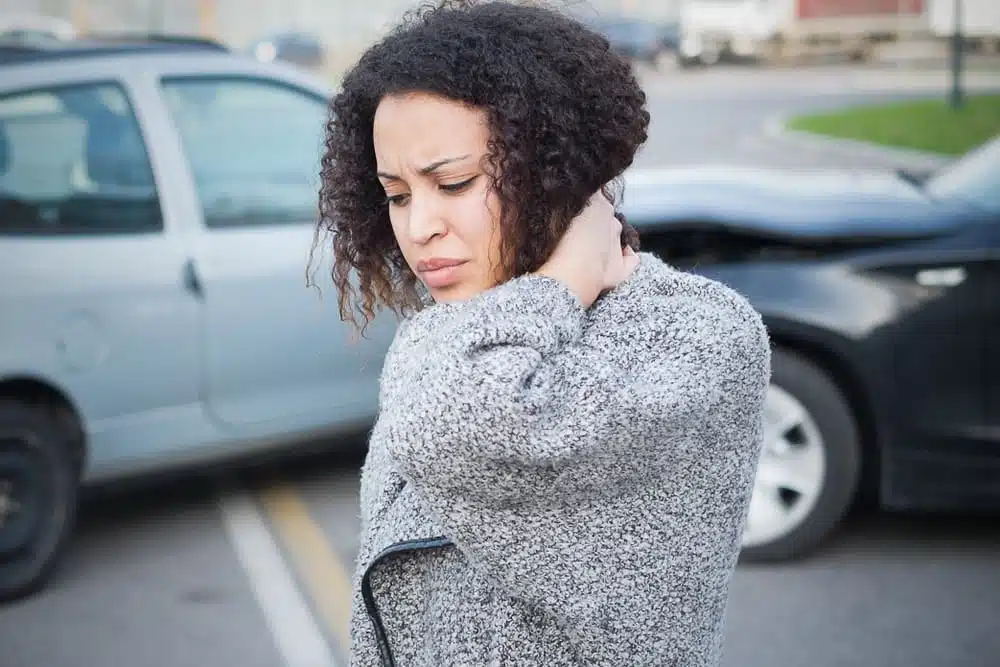 A woman having a whiplash after car accident