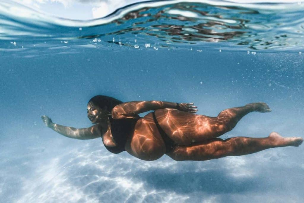 Woman in Black Bikini Swimming in Water