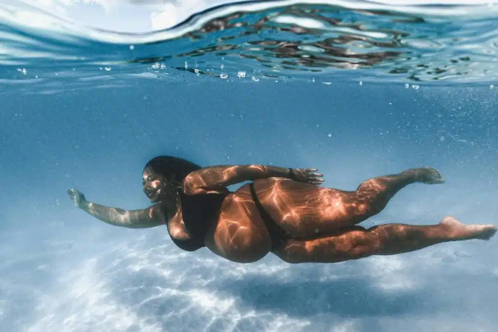 Woman in Black Bikini Swimming in Water