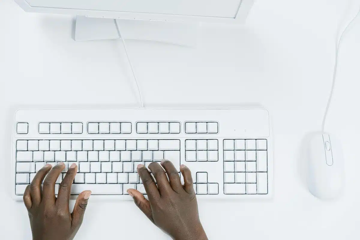 Hands typing on a white keyboard